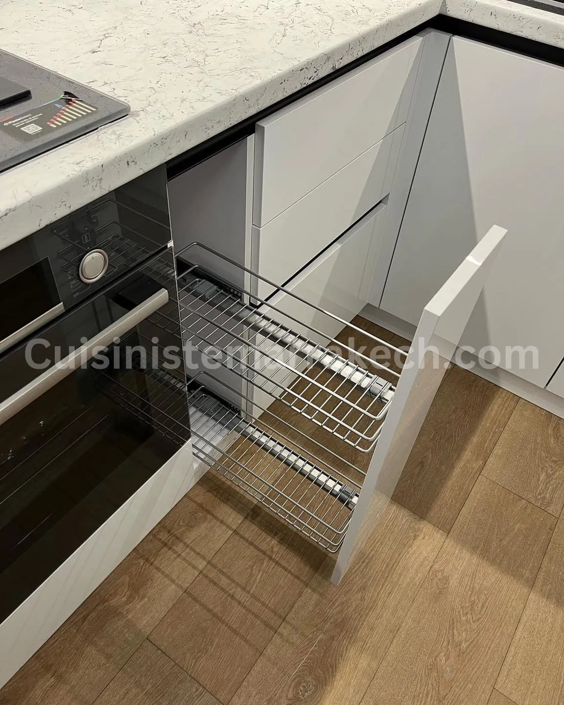 Détail d'un rangement coulissant chromé pleine extension dans une cuisine à Marrakech